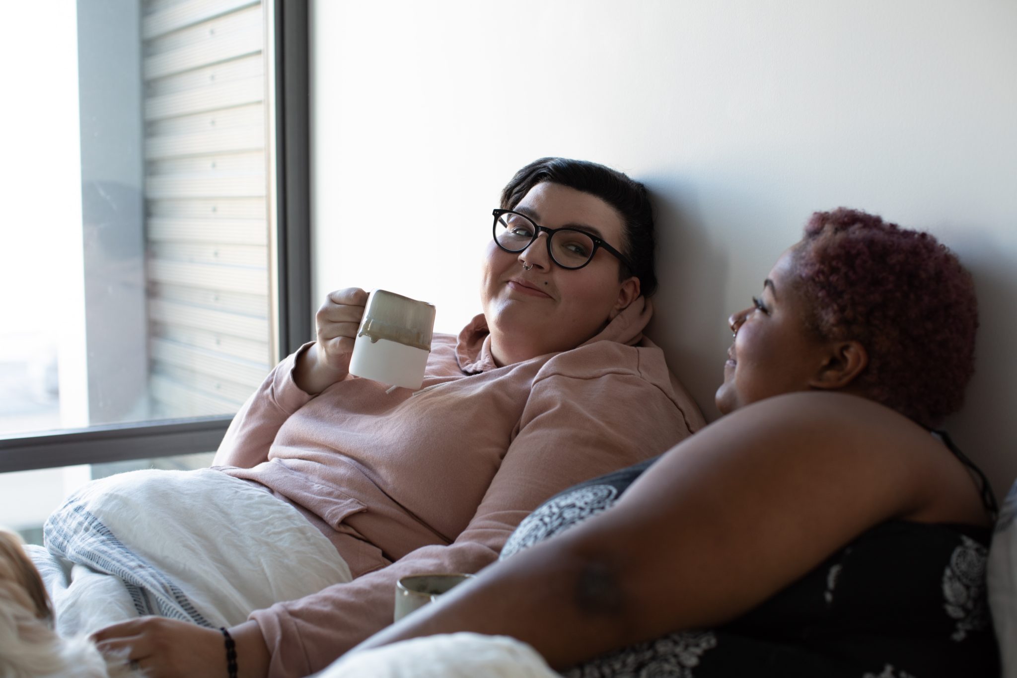 seksualnośc plus size niejedno ma imię: na zdjęciu dwie grube kobiety leżą w łóżku, patrząc sobie w oczy z czułością