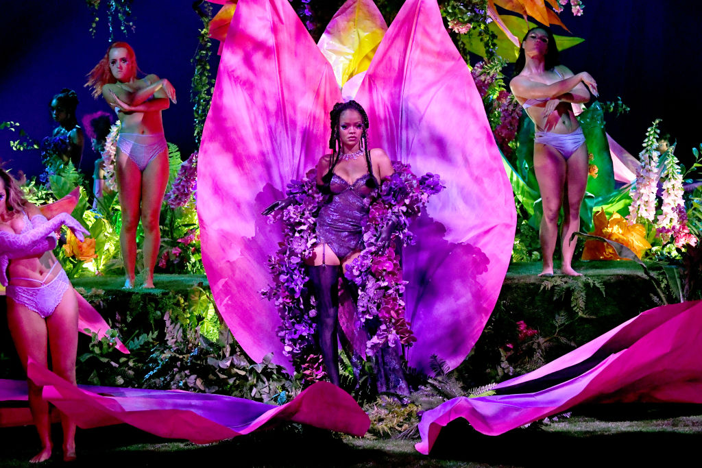 kadr z pokazu Sacage x Fenty - fotos Rihanny wychodzącej z wielkiego kwiatu - elemetu scenografii
